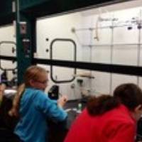 3 Girl scouts using science equipment